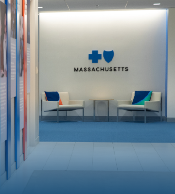 Add mobile image: cover-our-company-m.png --- Add ALT text: Blue Cross Blue Shield of MA office hallway with two chairs and company logo on wall Add mobile image: cover-our-company-m.png --- Add ALT text: Blue Cross Blue Shield of MA office hallway with two chairs and company logo on wall